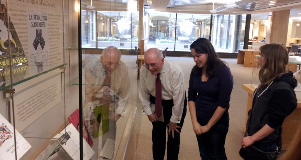 Students showing exhibit to library patrons