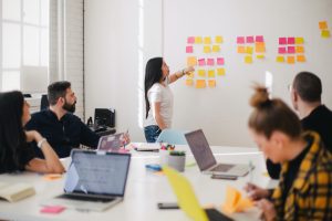 students doing an activity with post-it notes on a whiteboard