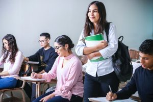 female student smiling in classroom with other students