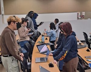 Two lines of college students in a classroom, playing a round of academic speed dating.