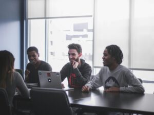 three male students facing a female student