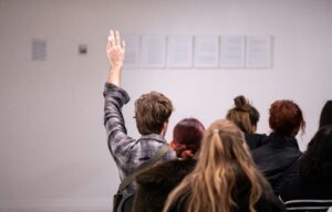 student raising hand in classroom