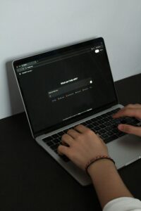 someone's hands at a laptop prompting ChatGPT